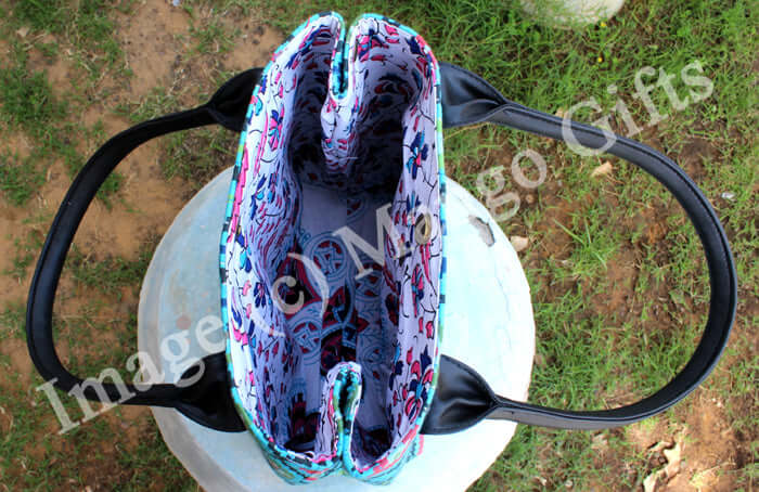 Inside view of a blue geometric cotton tote bag with leather straps, spacious with one inside pocket.