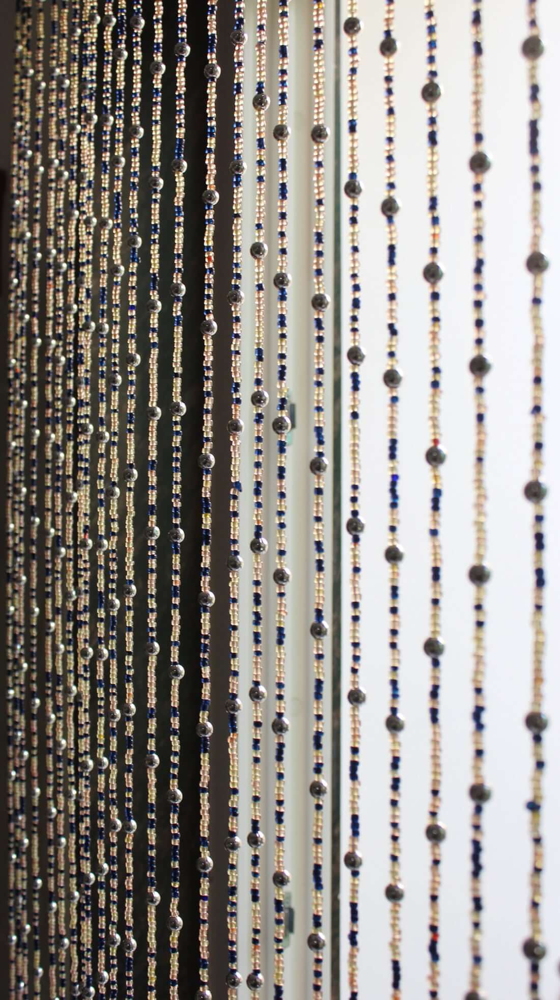 Handmade colorful glass bead strands with jingle bells—perfect for doorways or wall décor. Eco-friendly and crafted by women's artisans in India.