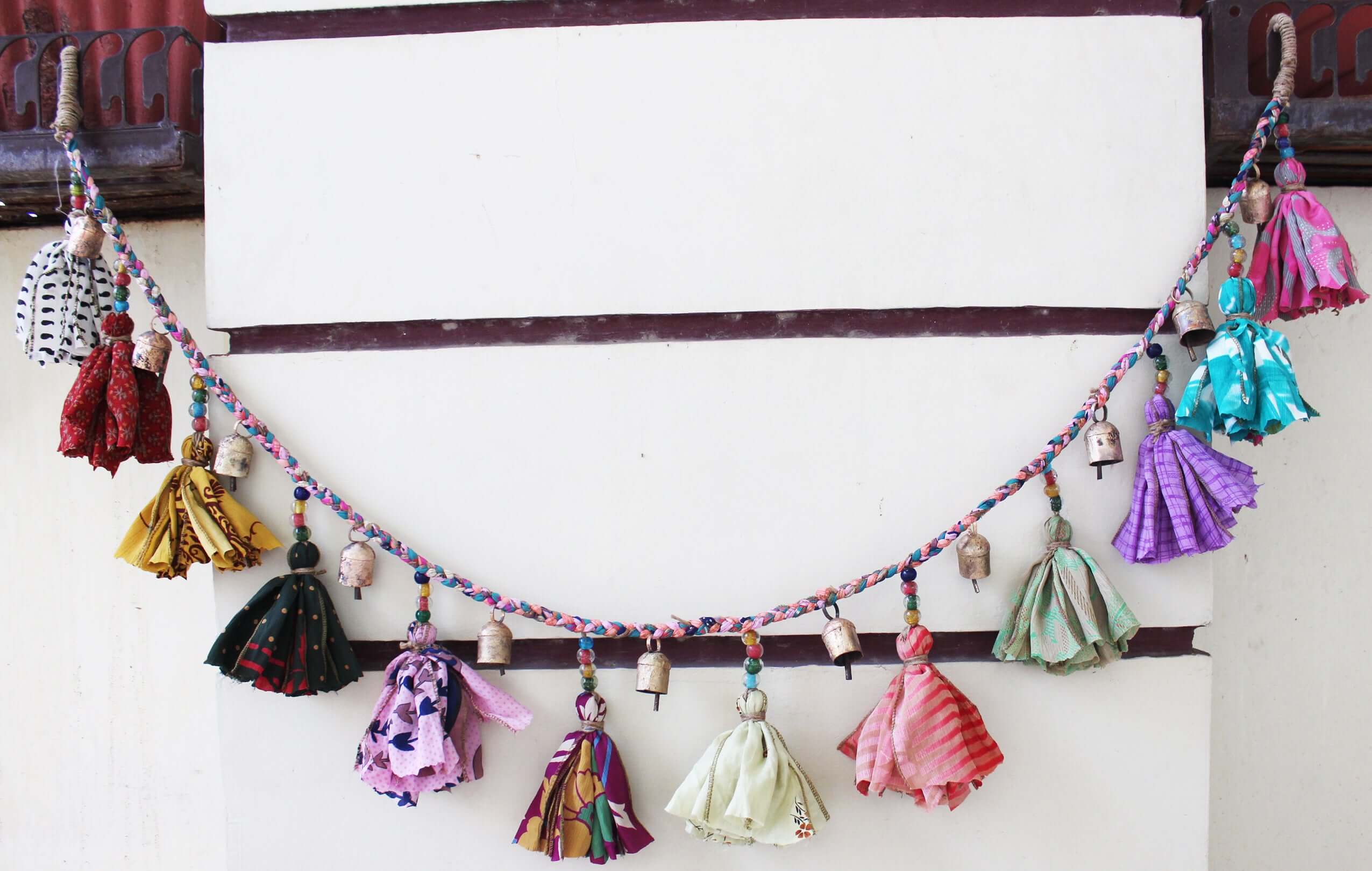 Adorn your space with this 5ft handmade garland of brass bells and glass beads. Perfect for parties and home decoration.
