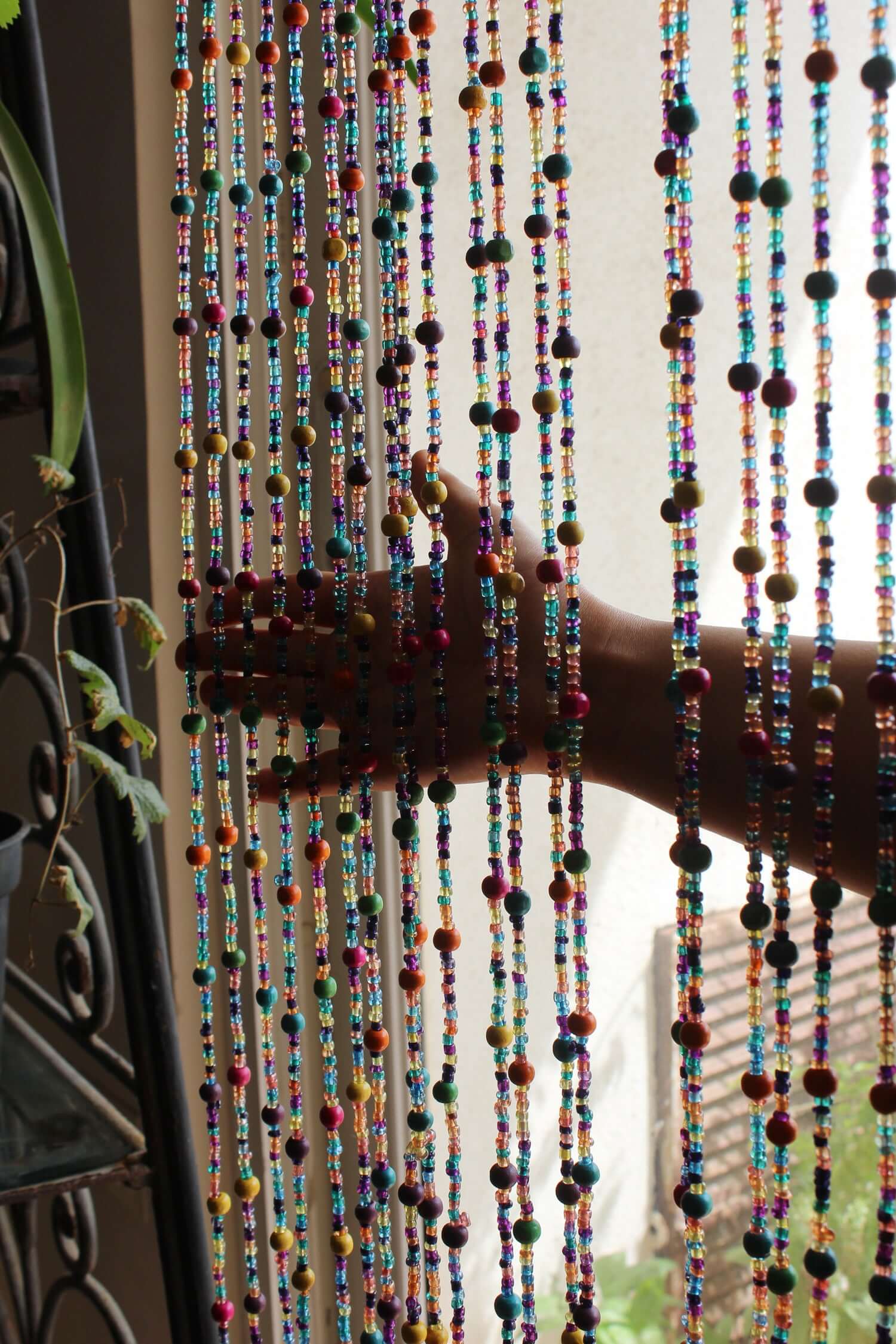 Handmade colorful glass bead strands with jingle bells—perfect for doorways or wall décor. Eco-friendly and crafted by women's artisans in India.