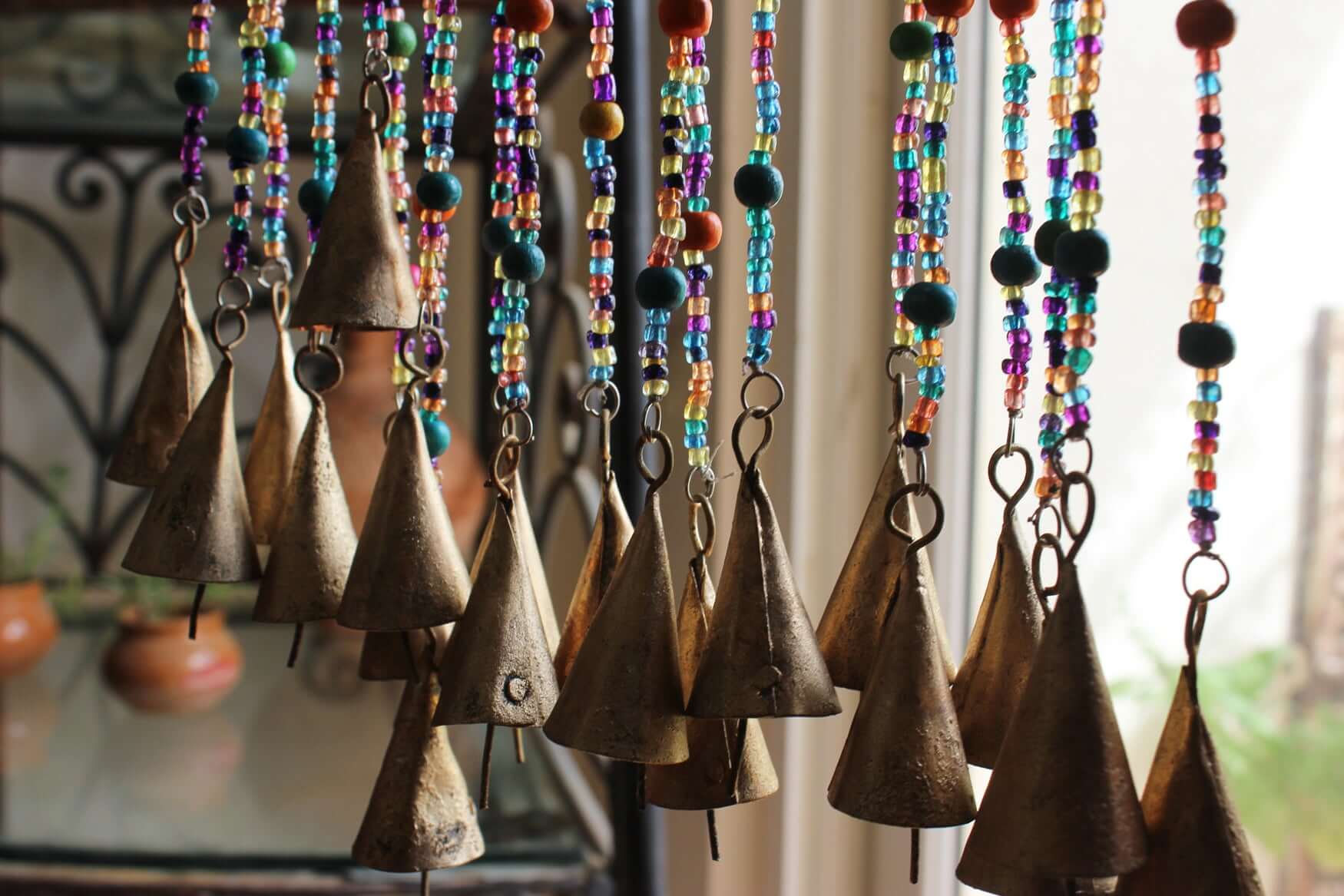 Handmade colorful glass bead strands with jingle bells—perfect for doorways or wall décor. Eco-friendly and crafted by women's artisans in India.