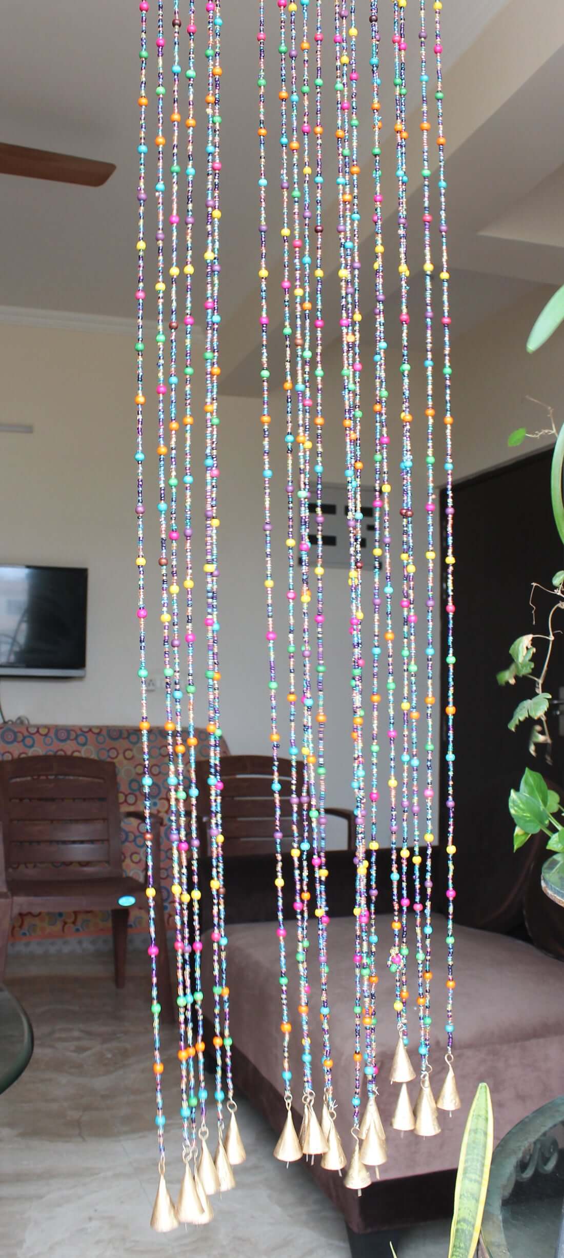 Handmade colorful glass bead strands with jingle bells—perfect for doorways or wall décor. Eco-friendly and crafted by women's artisans in India.