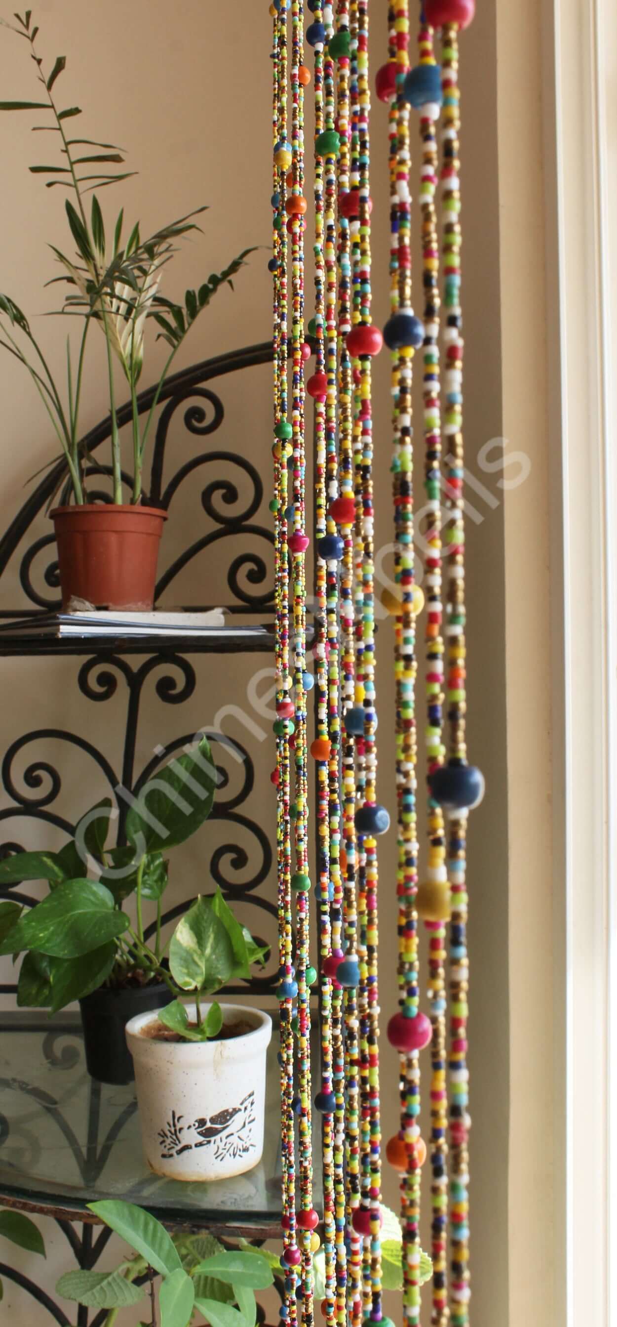 Colorful bohemian beaded doorway garland with jingle bells, enhancing a vibrant home decor.