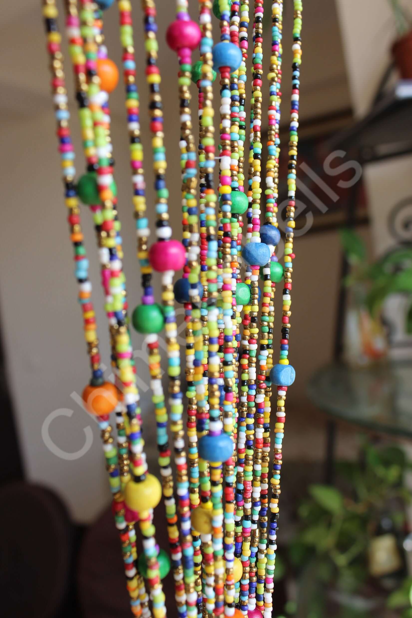 Colorful beaded doorway garland featuring multicolored beads and jingle bells, perfect for bohemian decor.