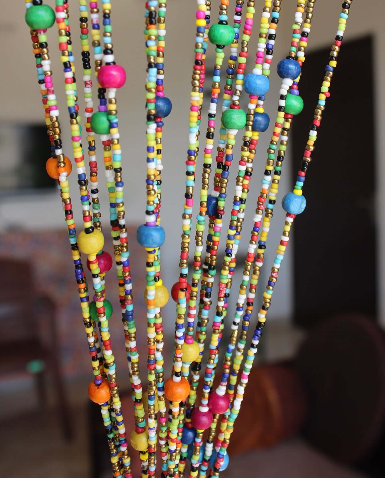 Colorful bohemian beaded doorway garland with vibrant multicolored beads and playful jingle bells.