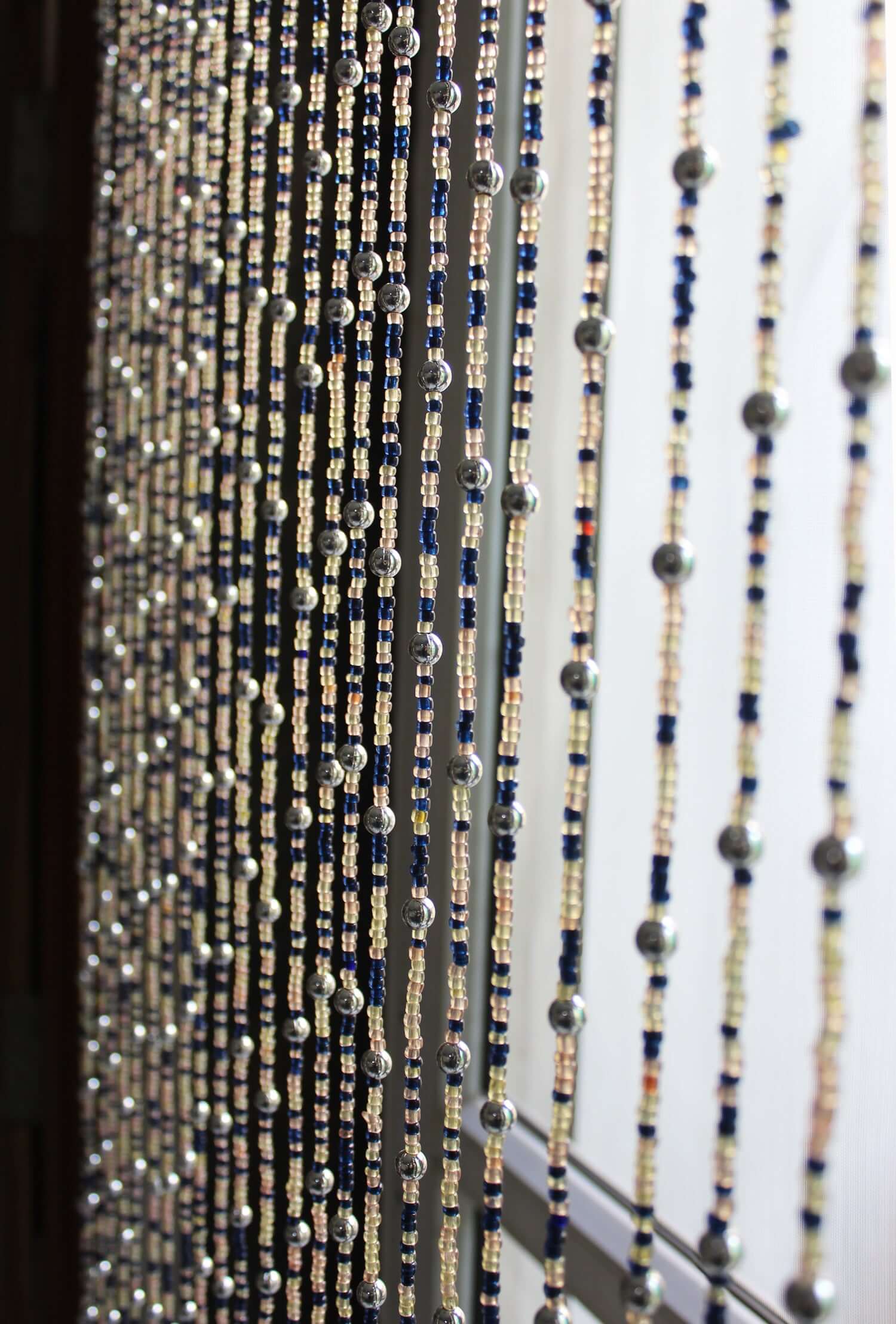 Handmade colorful glass bead strands with jingle bells—perfect for doorways or wall décor. Eco-friendly and crafted by women's artisans in India.