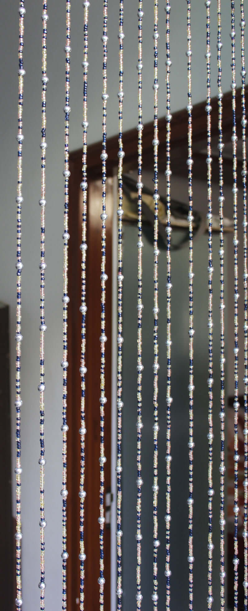 Handmade colorful glass bead strands with jingle bells—perfect for doorways or wall décor. Eco-friendly and crafted by women's artisans in India.