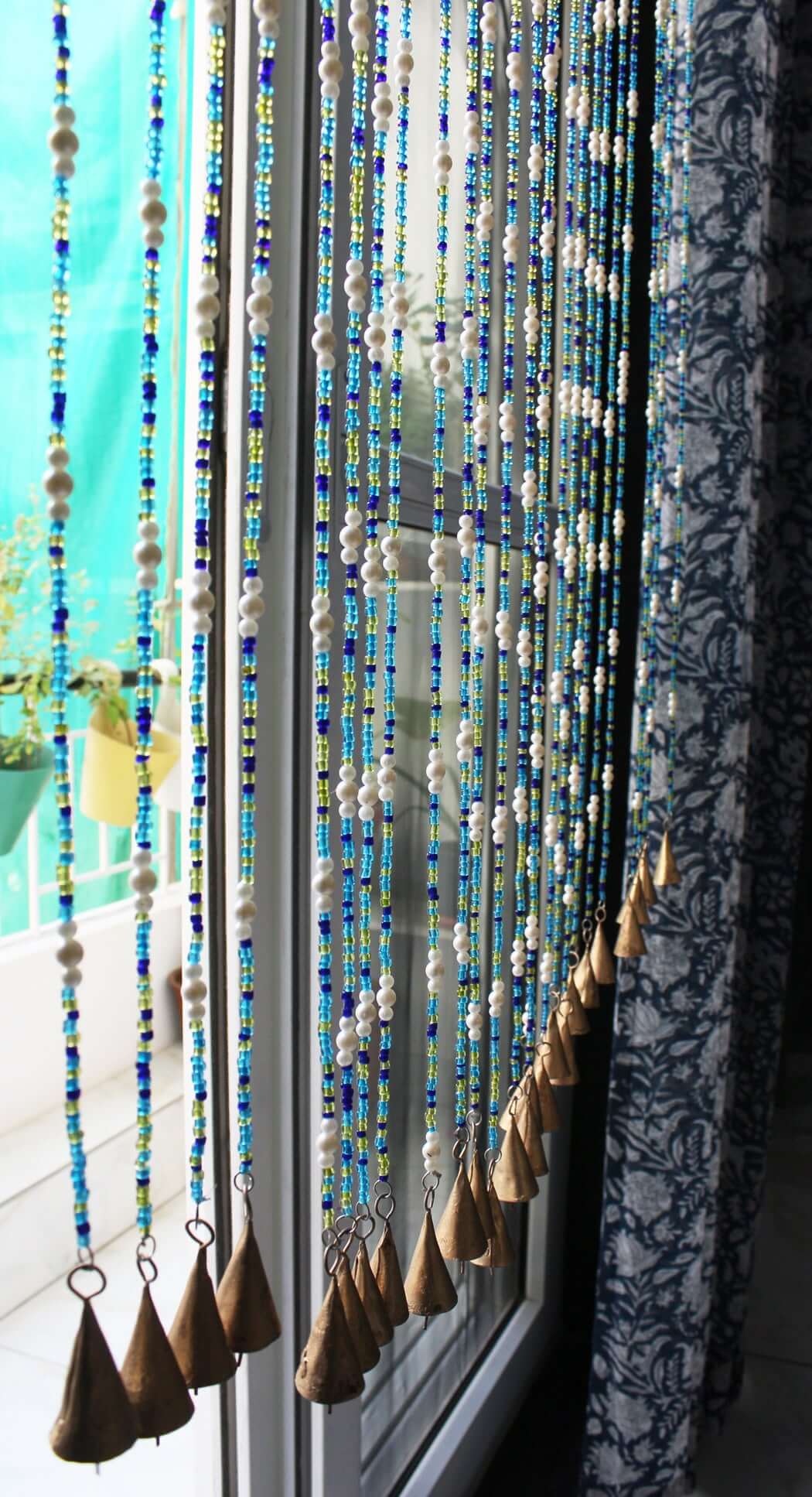 Handmade colorful glass bead strands with jingle bells—perfect for doorways or wall décor. Eco-friendly and crafted by women's artisans in India.