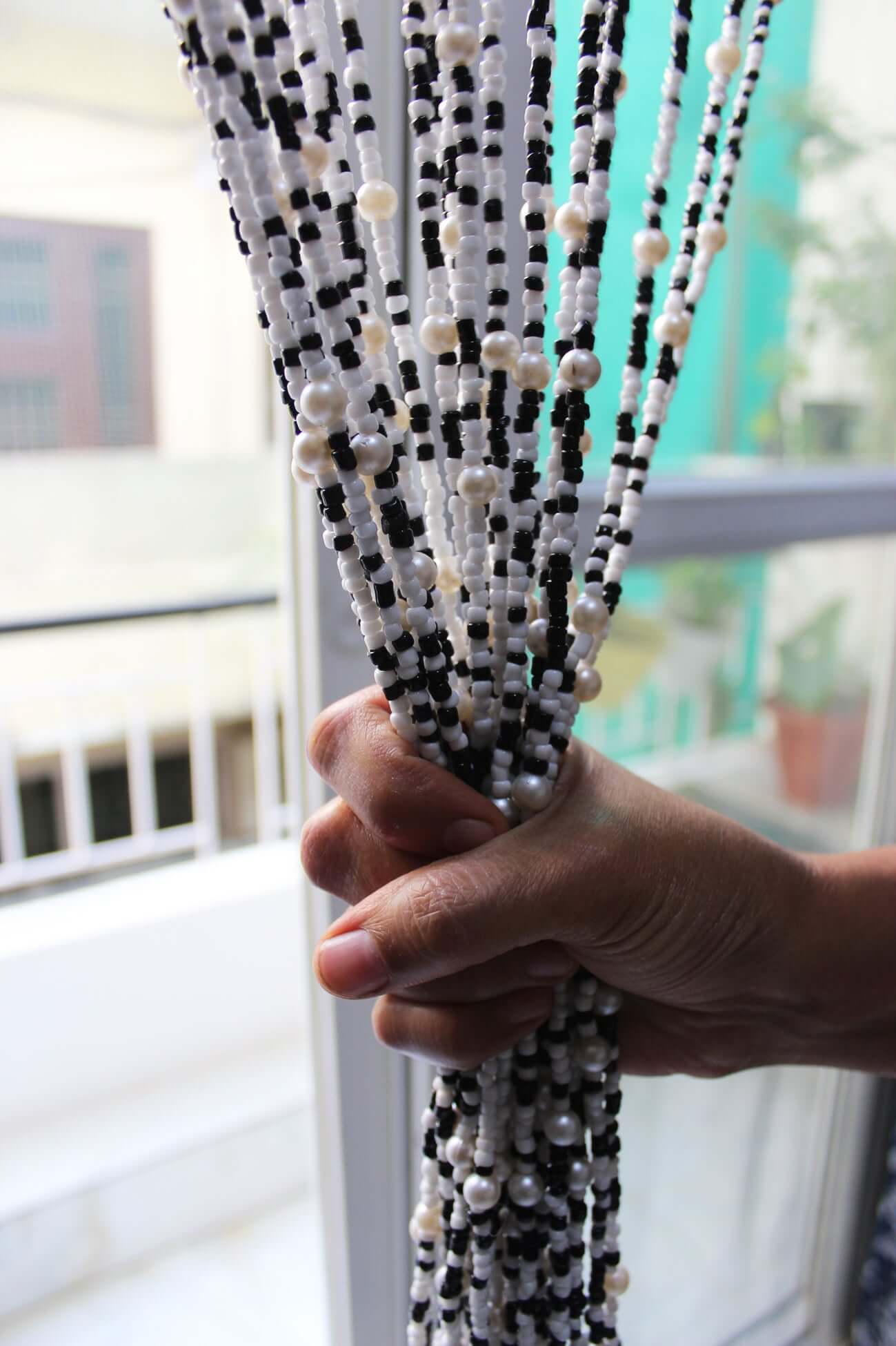 Handmade colorful glass bead strands with jingle bells—perfect for doorways or wall décor. Eco-friendly and crafted by women's artisans in India.