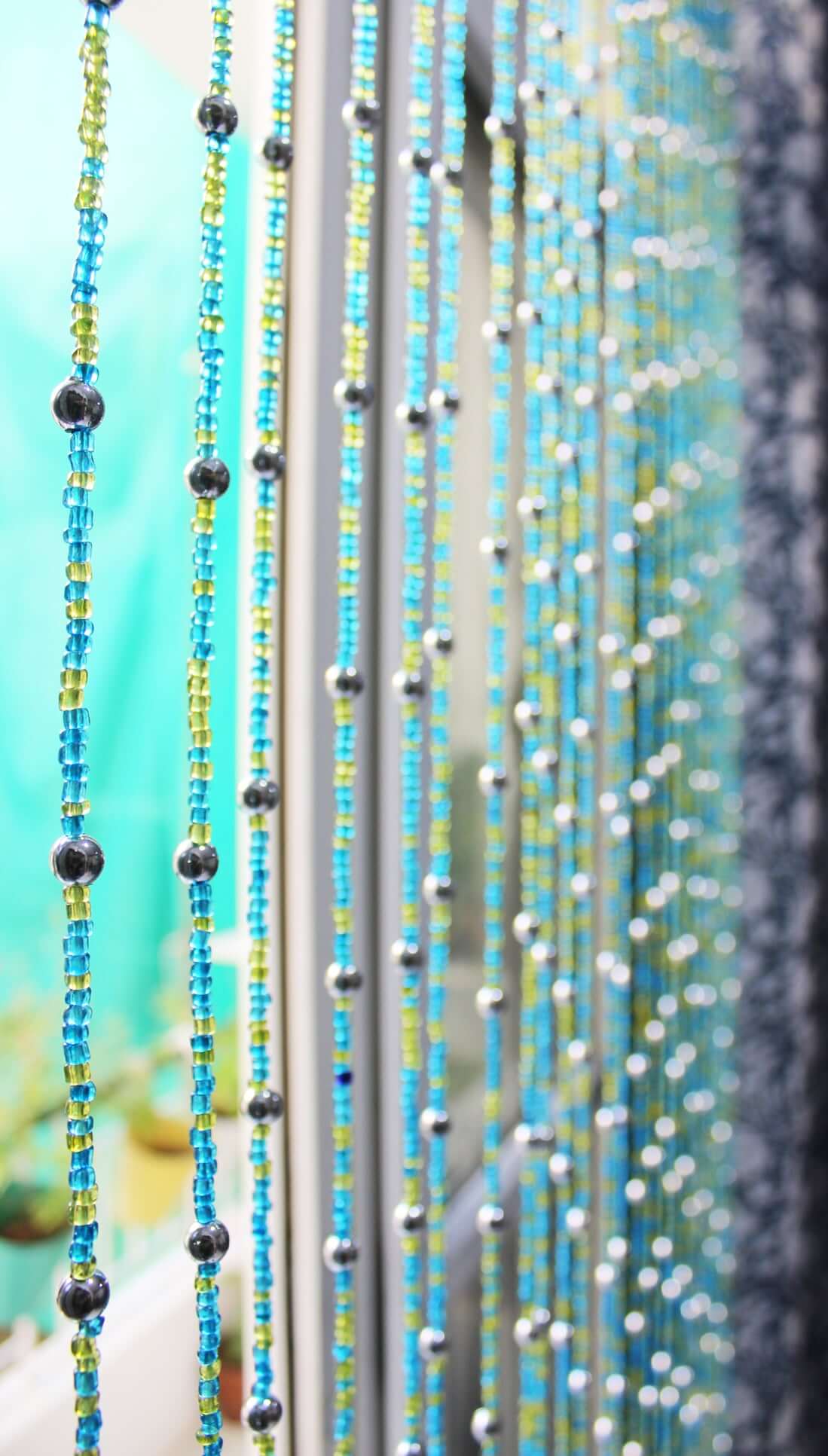 Handmade colorful glass bead strands with jingle bells—perfect for doorways or wall décor. Eco-friendly and crafted by women's artisans in India.