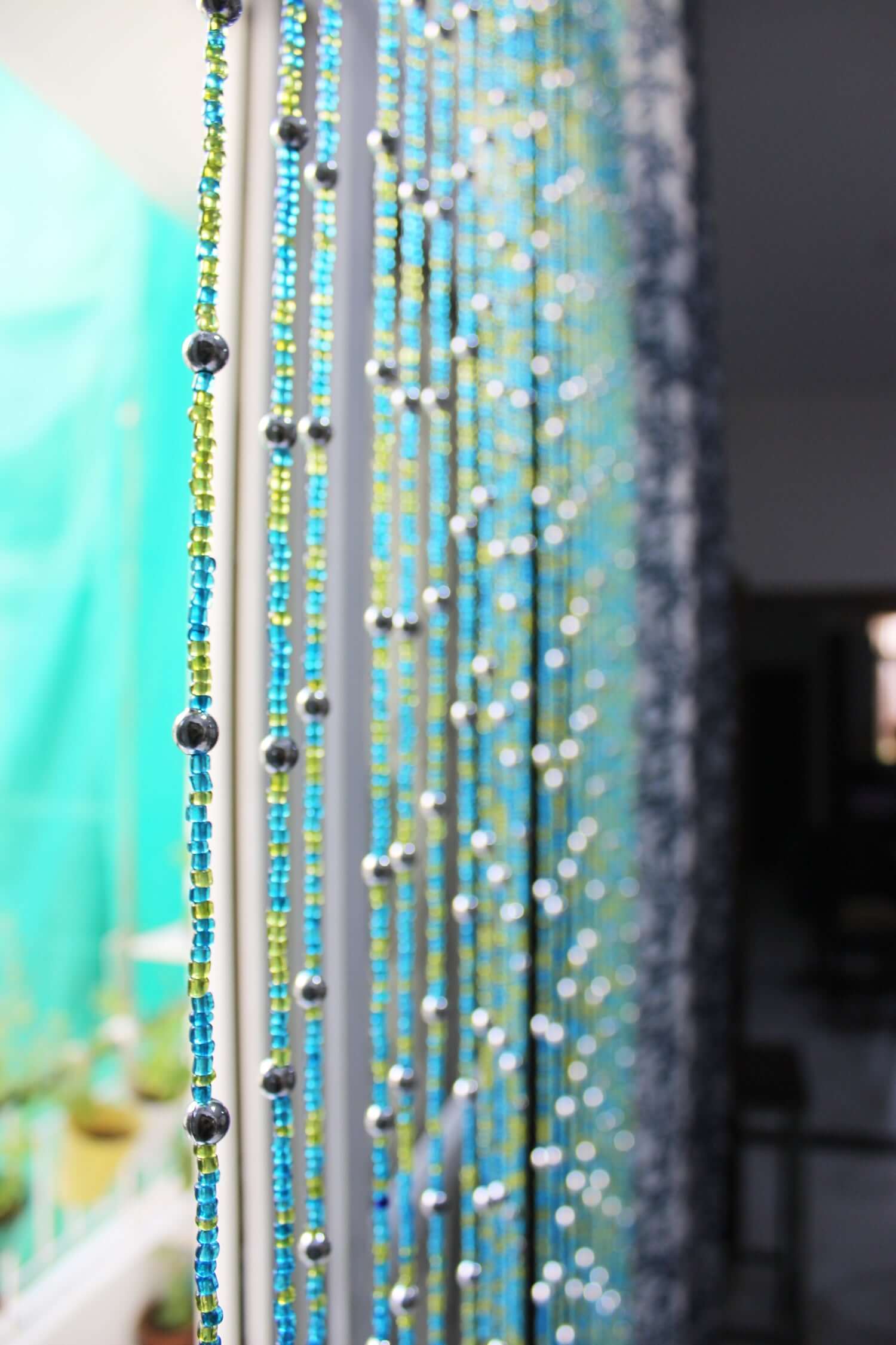Handmade colorful glass bead strands with jingle bells—perfect for doorways or wall décor. Eco-friendly and crafted by women's artisans in India.