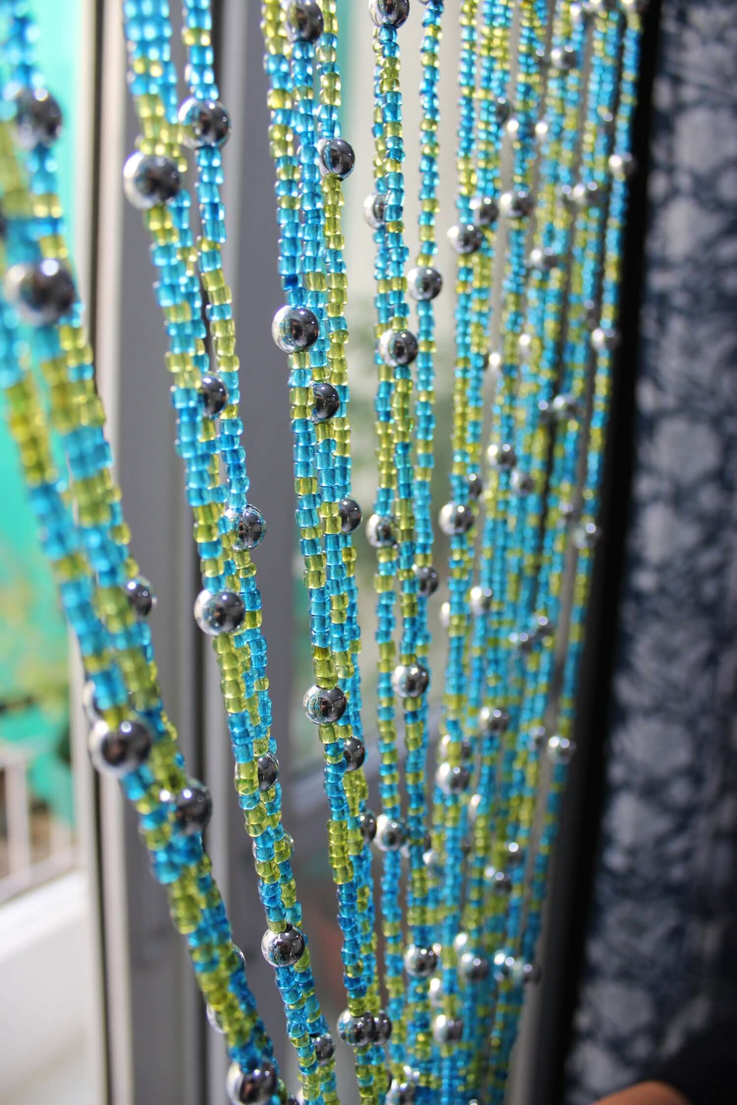 Handmade colorful glass bead strands with jingle bells—perfect for doorways or wall décor. Eco-friendly and crafted by women's artisans in India.