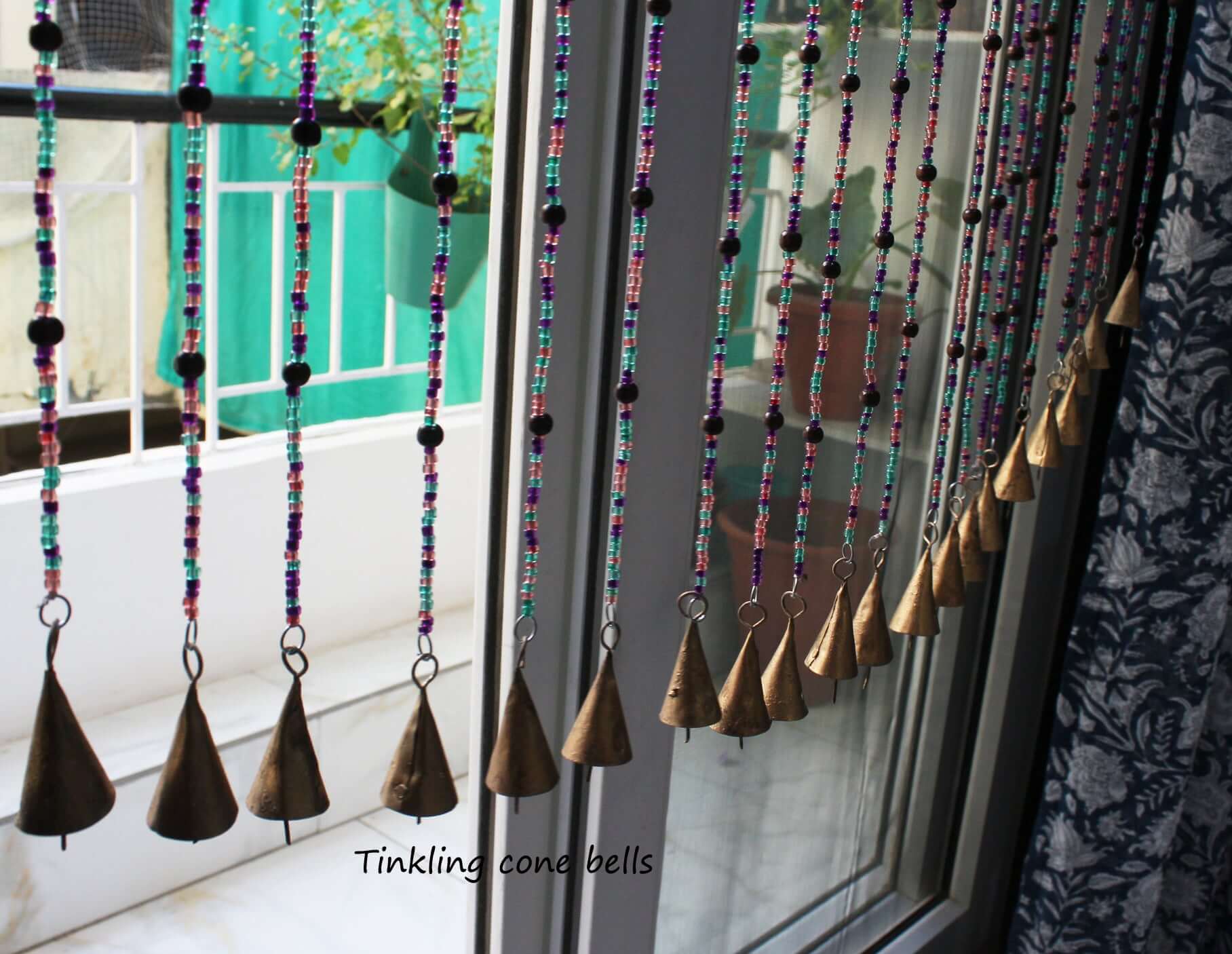 Handmade colorful glass bead strands with jingle bells—perfect for doorways or wall décor. Eco-friendly and crafted by women's artisans in India.