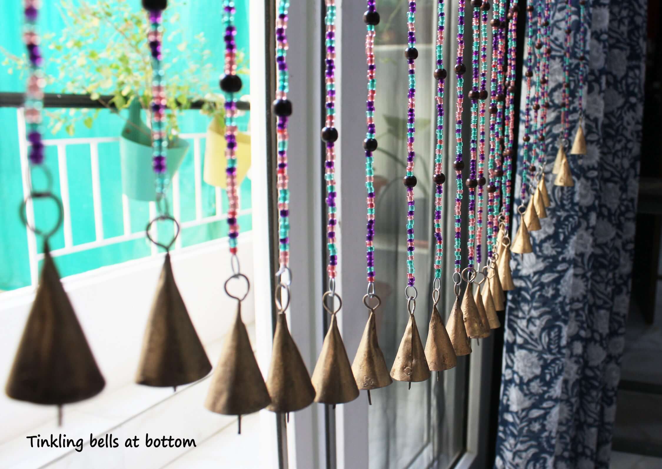 Handmade colorful glass bead strands with jingle bells—perfect for doorways or wall décor. Eco-friendly and crafted by women's artisans in India.