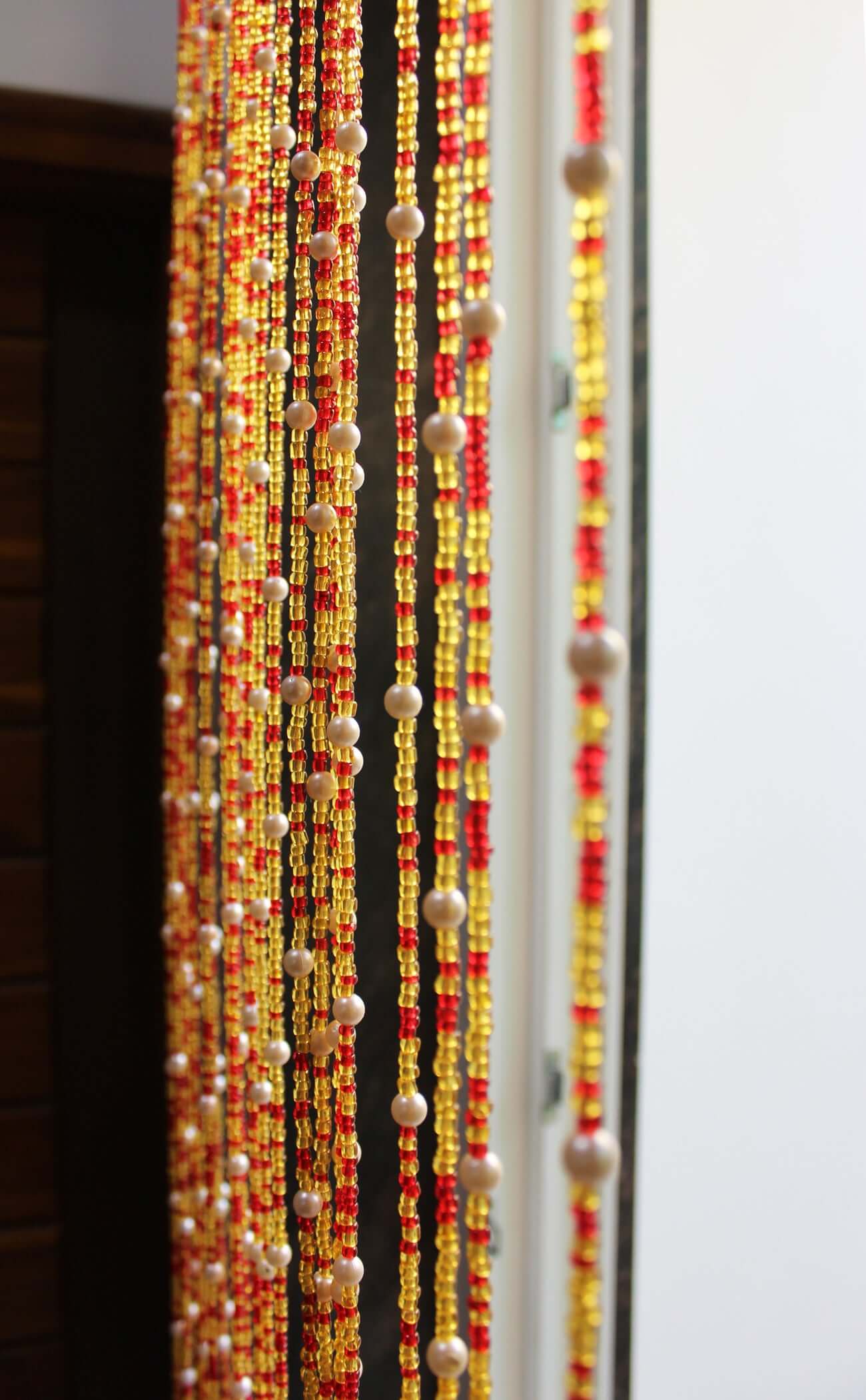 Handmade colorful glass bead strands with jingle bells—perfect for doorways or wall décor. Eco-friendly and crafted by women's artisans in India.