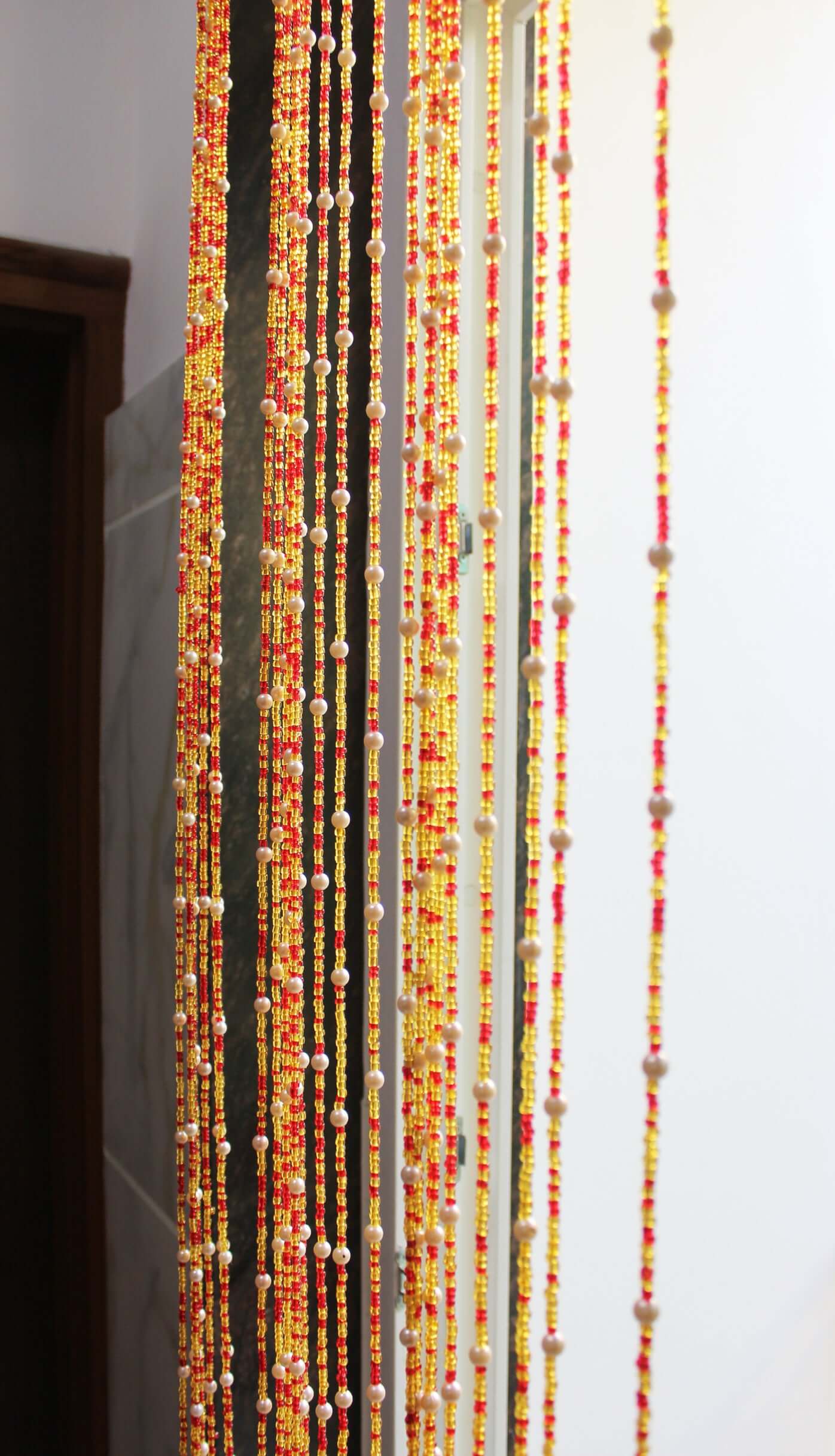 Handmade colorful glass bead strands with jingle bells—perfect for doorways or wall décor. Eco-friendly and crafted by women's artisans in India.