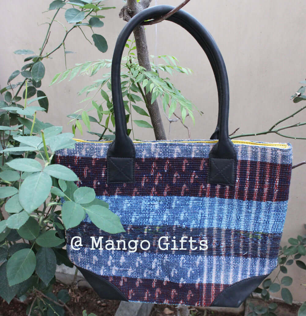 Handmade Chindi rug tote bag with leather straps, featuring a multi-colored design, perfect for shopping or picnics.