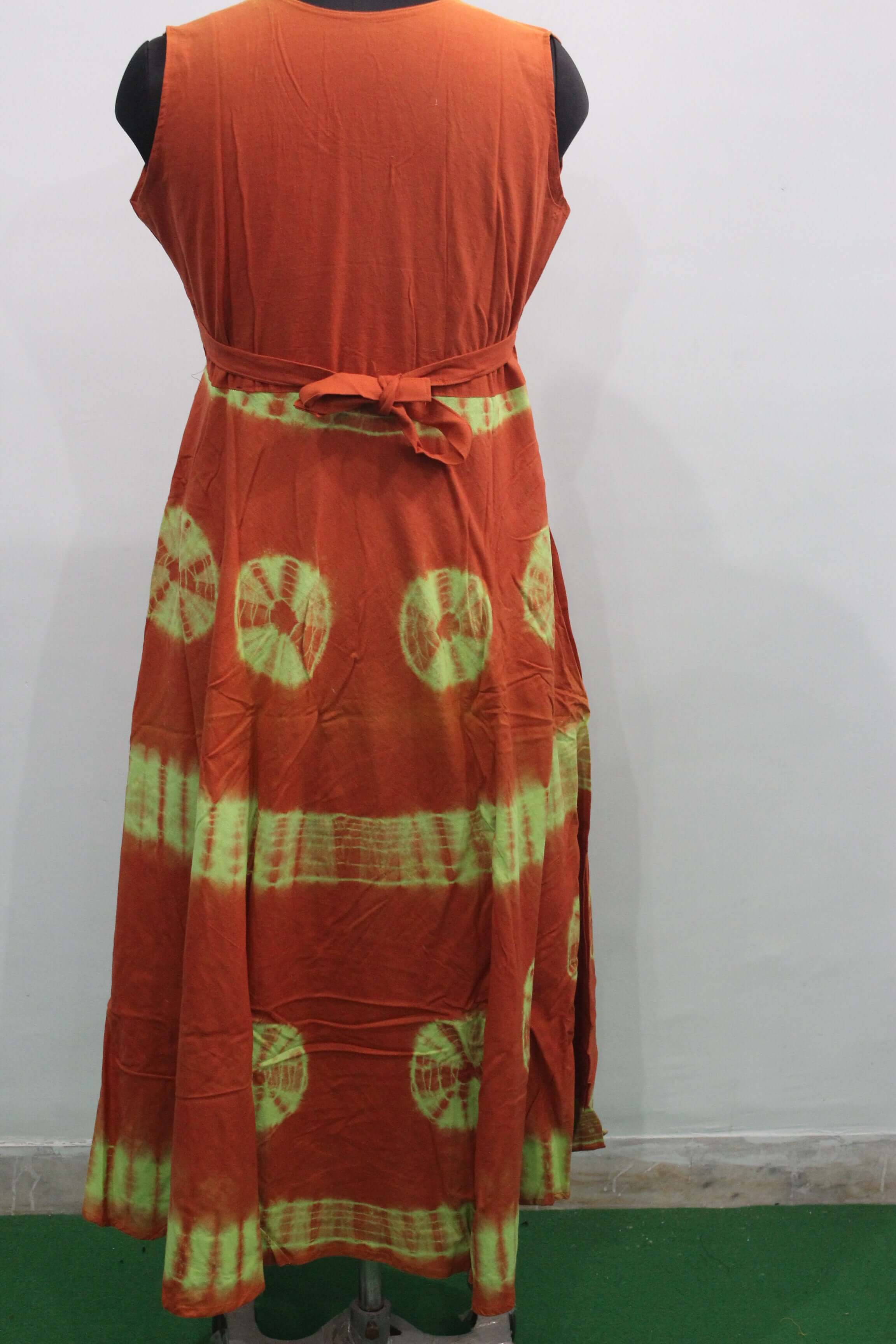 Back view of a cotton tie-dye maxi dress with orange and green patterns, featuring a belt for a boho style.