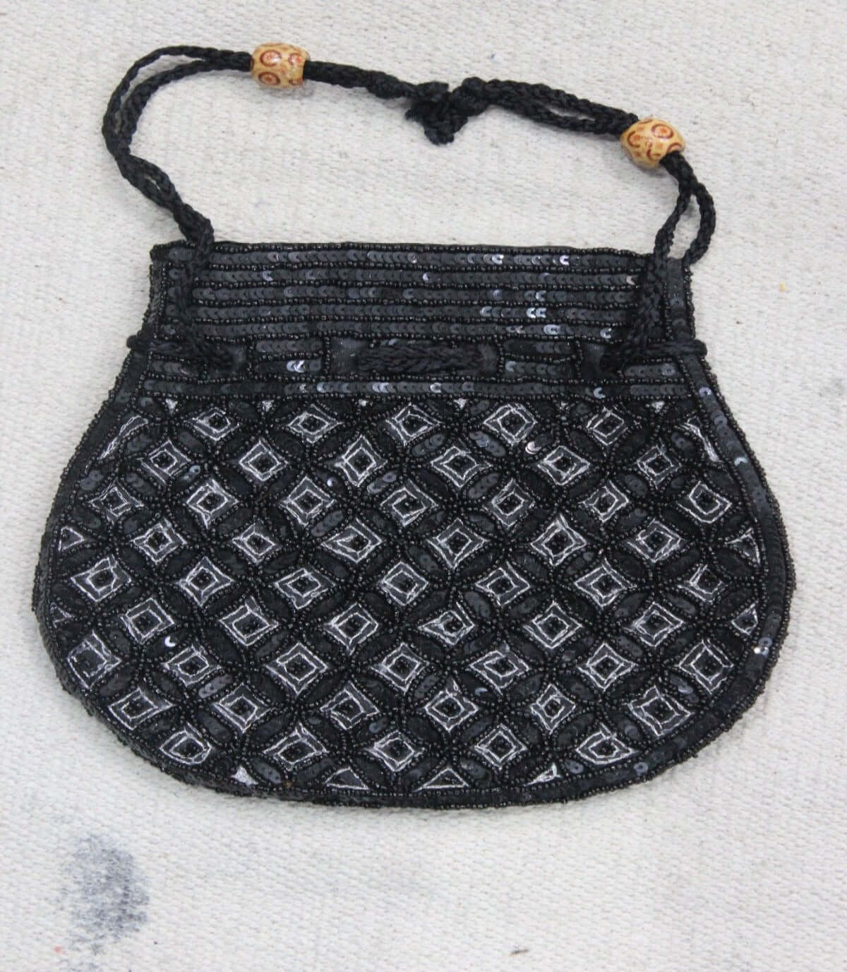 Beautiful black handmade potli bag with sequins, featuring intricate designs and adjustable strings for carrying.