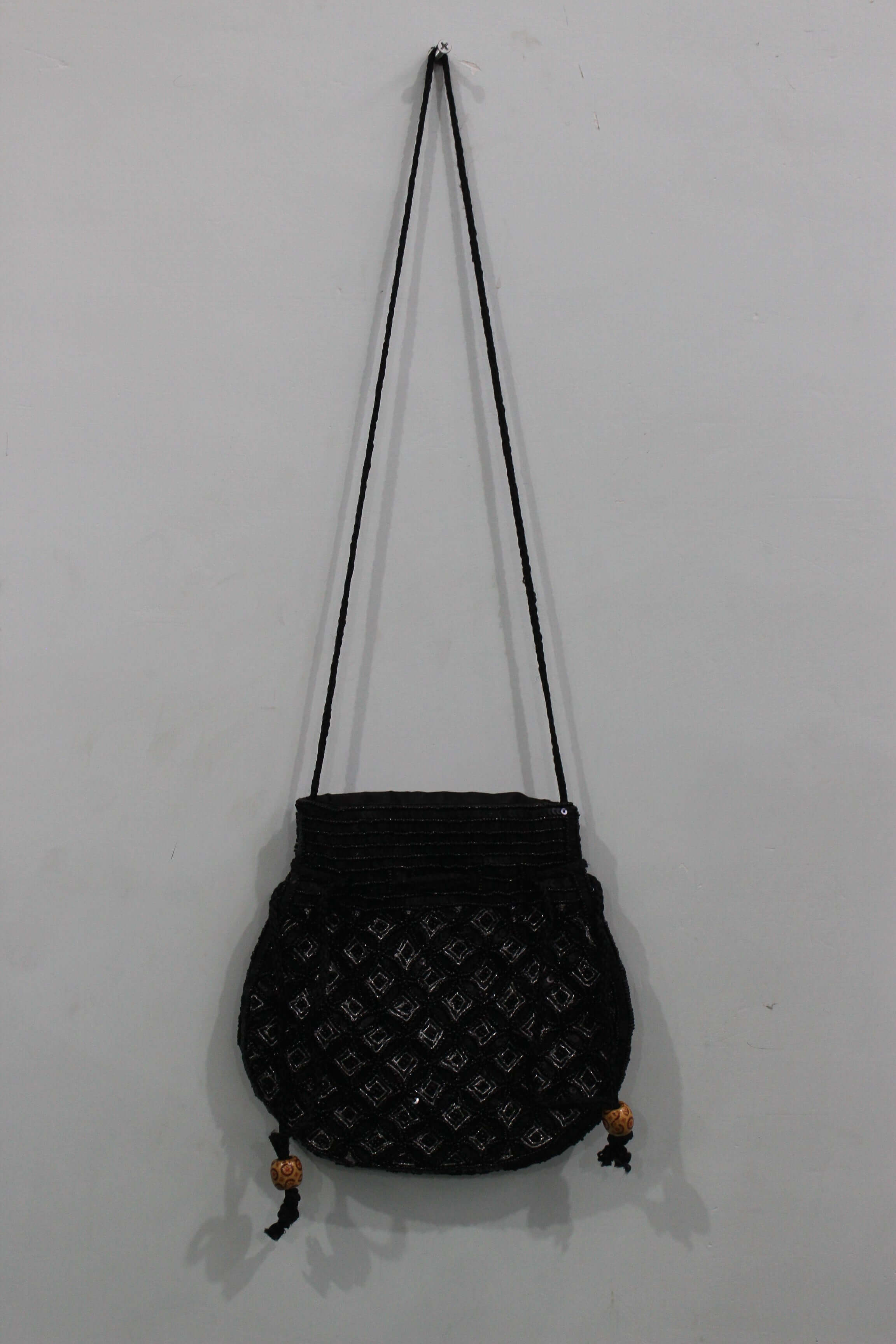 Beautiful handmade black potli bag with sequins, featuring a sling strap and decorative beads, perfect for fashion.