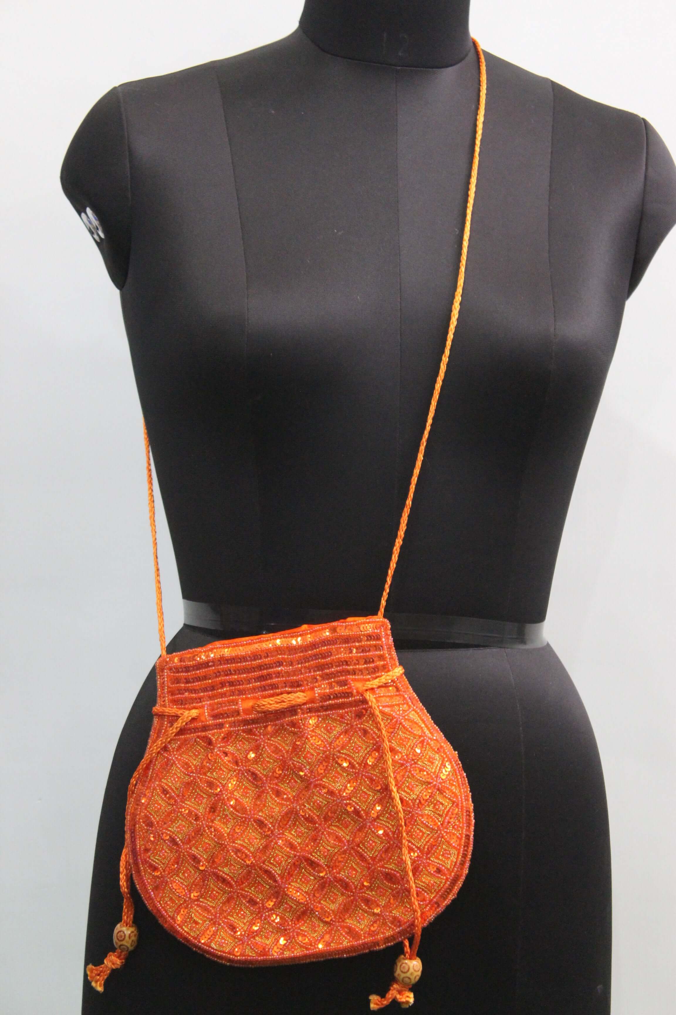 Beautiful orange handmade Indian potli bag with sequins, perfect for fashion and small articles.