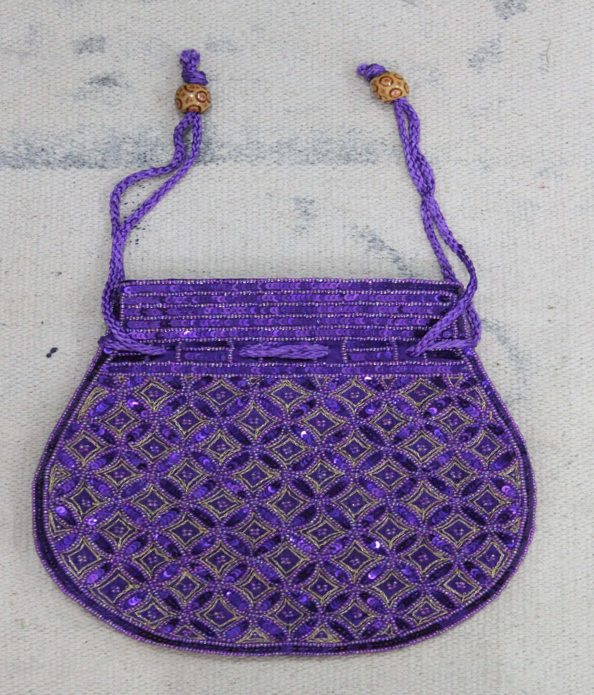 Beautiful purple handmade Indian Potli bag adorned with sequins, perfect for carrying small articles.