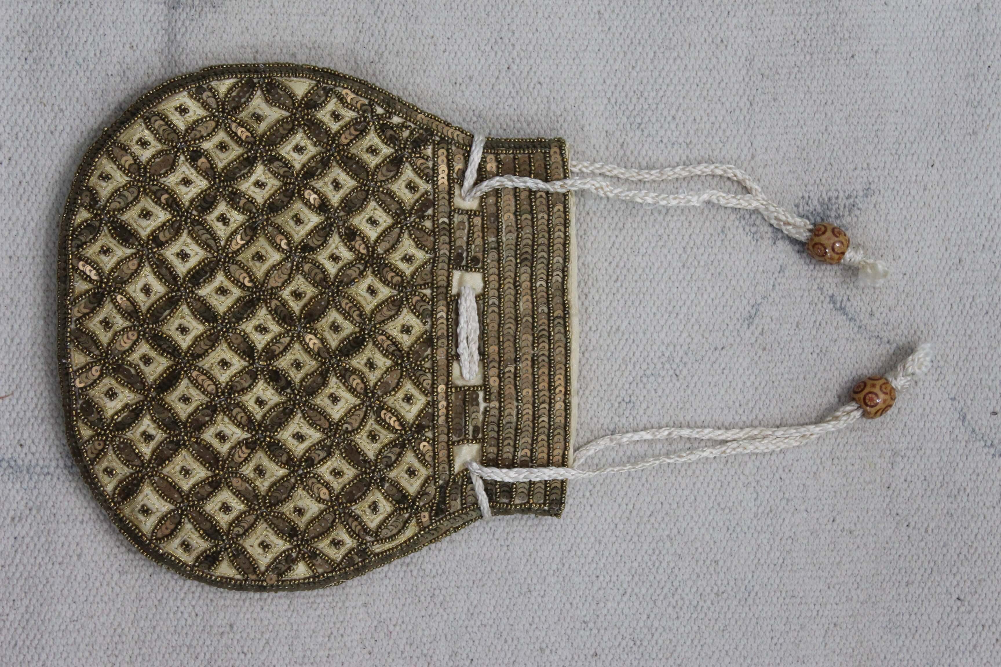 Beautiful olive golden handmade Indian potli bag with intricate sequins and decorative strings.