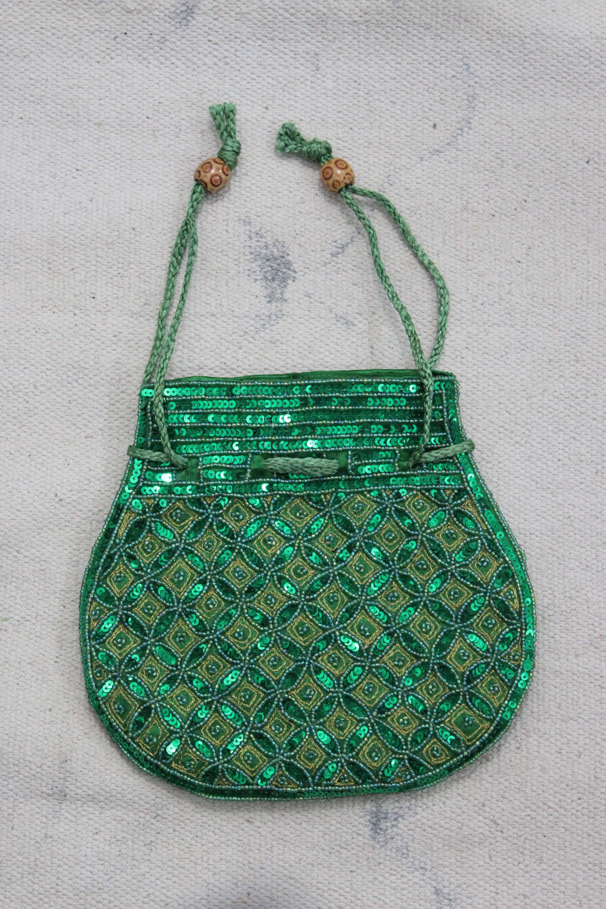 Beautiful green handmade Indian potli bag with sequins, perfect for carrying small essentials stylishly.