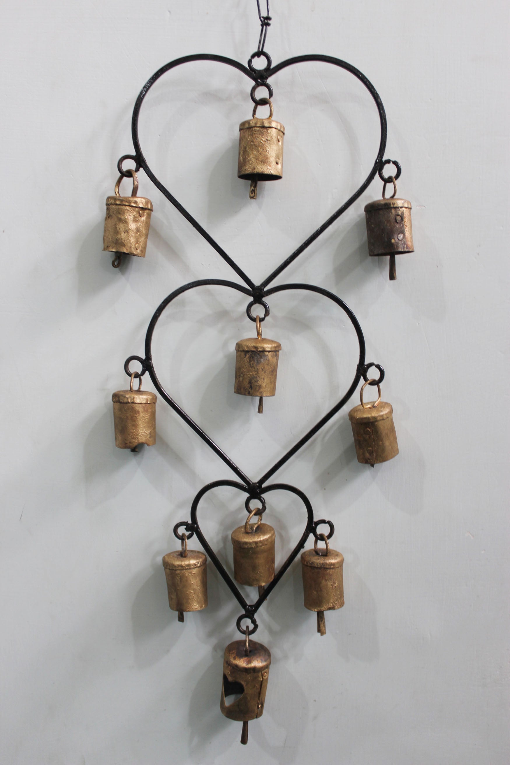 Beautiful handcrafted wind chime made from recycled iron, featuring gold bells. Perfect for home décor or as a thoughtful gift.