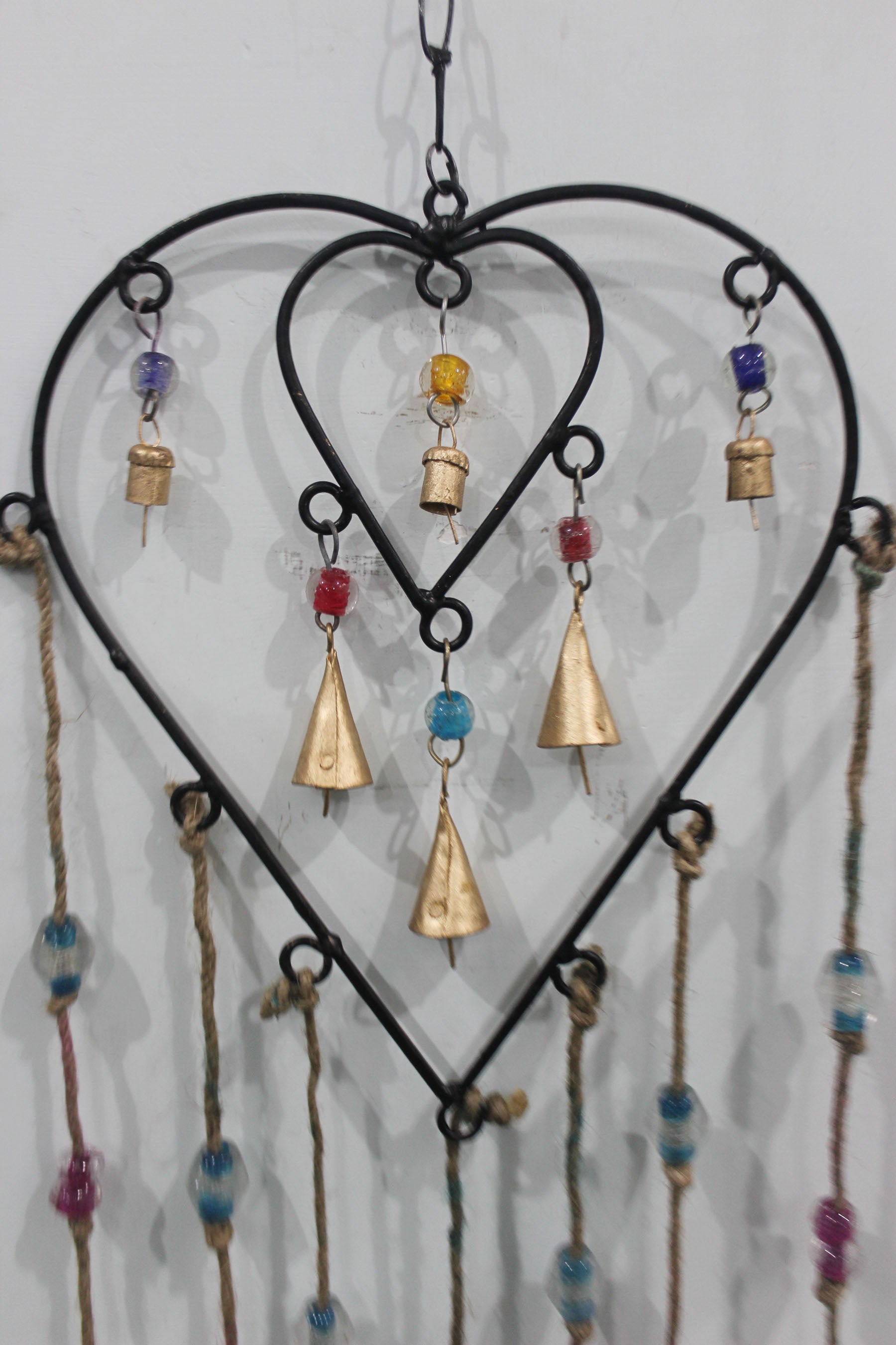Charming recycled iron heart wind chime with colorful glass beads. Perfect for gifts or adding a loving touch to your patio.
