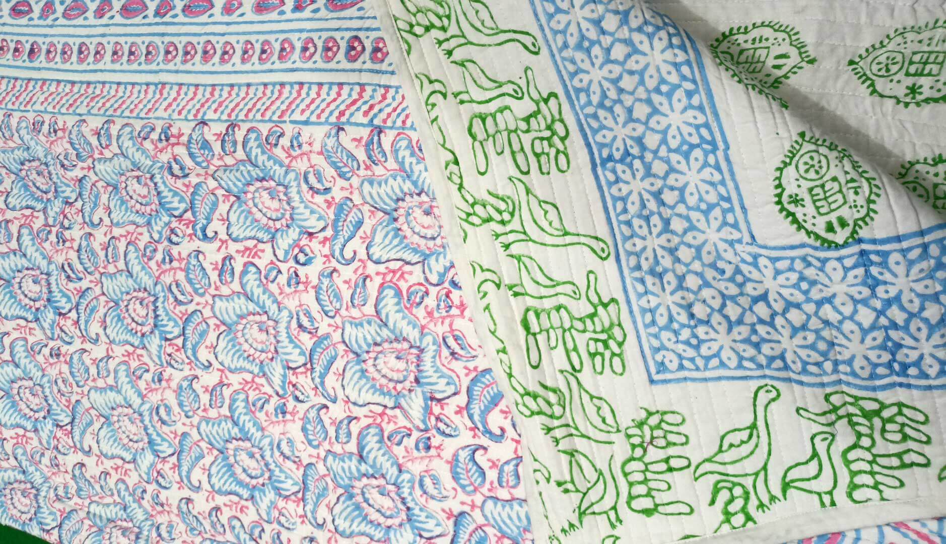 Floral reversible cotton quilt with handblock print in pink and green, showcasing traditional Jaipur design.