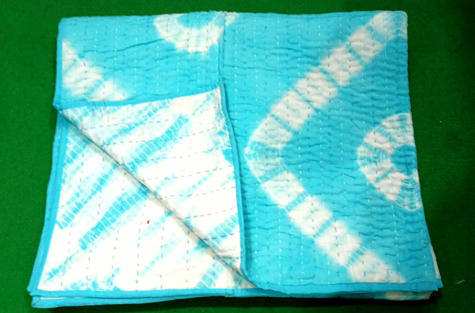 Cotton tie dye thin quilt in turquoise, perfect as a sofa throw or bed cover, measures 55 x 89 inches.